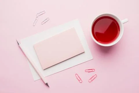 Red-pink objects. Cup of tea and Notepad for text on pastel pink background.. Stock-Fotos