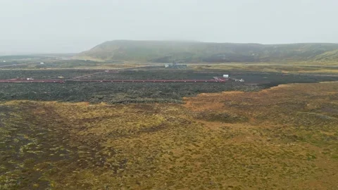 Red pipe on the ground running to the Geothermal Power Plant 库存影片 233036152