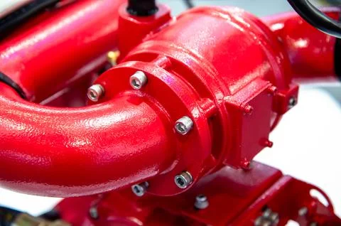 A red pipe with a red cap and bolts Stock Photos
