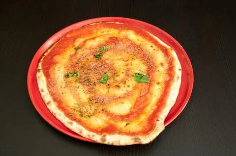 A red pizza with cheese and herbs on top Stock Photos