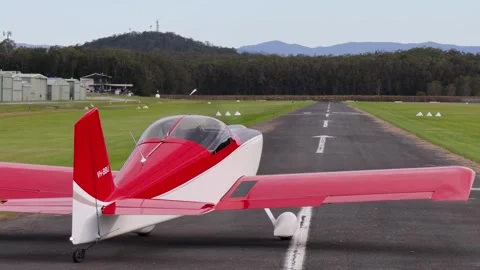 Red Plane Takes Off Against Mountain Backdrop Vídeos de archivo 309272885