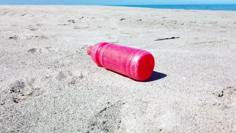 Red plastic bottle on the sand Stock Footage 186833770