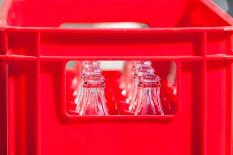 Red plastic crate with empty glass bottles Foto stock