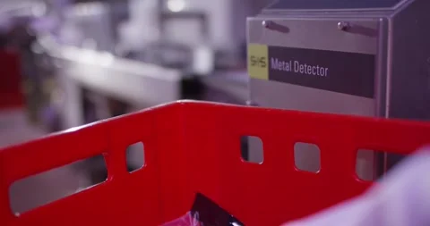 Red plastic crate in front of a metal detector unit, Food Factory Stock Footage 340015517