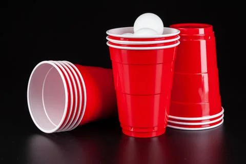 Red plastic cups and ball for game of beer pong Stock Photos