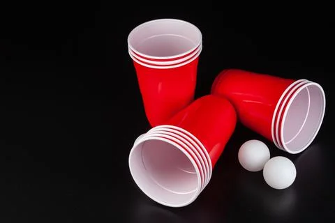 Red plastic cups and ball for game of beer pong Stock Photos