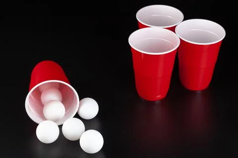 Red plastic cups and ball for game of beer pong Stock Photos