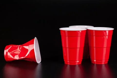 Red plastic cups and ball for game of beer pong Stock Photos