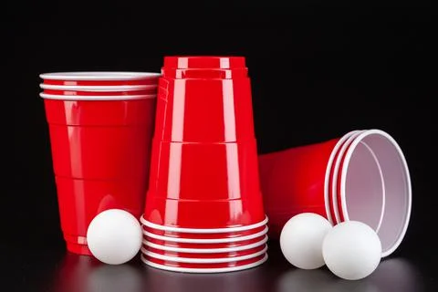 Red plastic cups and ball for game of beer pong Stock Photos