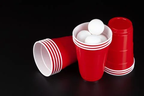 Red plastic cups and ball for game of beer pong Foto stock