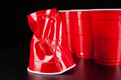 Red plastic cups and ball for game of beer pong Stock Photos