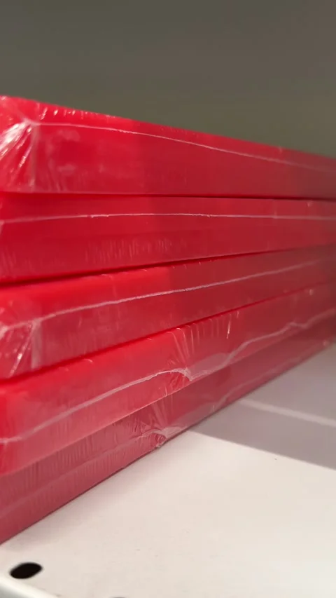 Red plastic cutting boards stacked on retail shelves in a kitchenware store Stock Footage 345174826