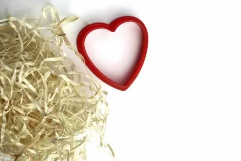 Red plastic heart shape and natural filler. Romantic, love card. Copy space - Stock Photos