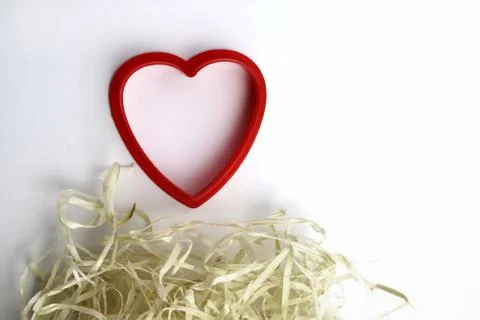 Red plastic heart shape and natural filler. Romantic, love card. Copy space - Stock Photos