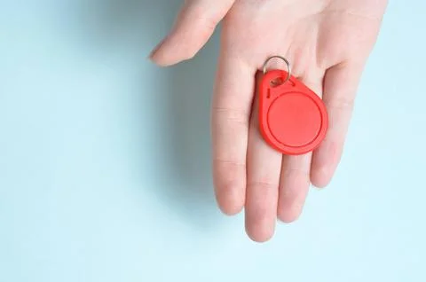 Red plastic intercom keychain. Blue background. Stock Photos