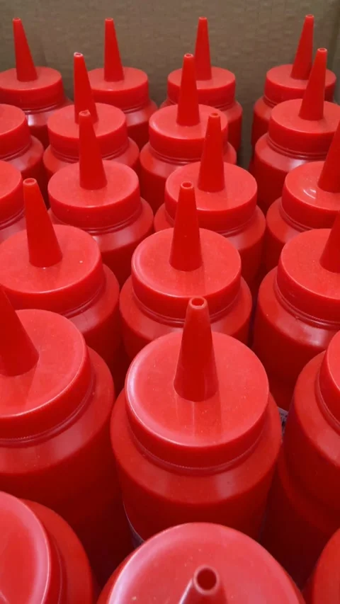 Red plastic ketchup bottles arranged in a box creating a repetitive pattern.. Stock Footage 331147423