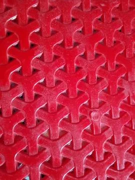 Red plastic mesh pattern with geometric y shapes geometric interlocking Stock-Fotos