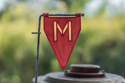 Red plastic minefield pointer with a mine in the background. Foto stock