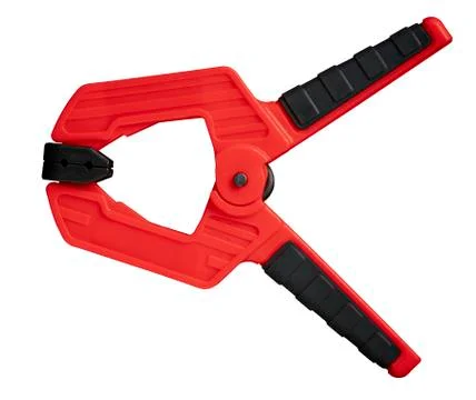 Red plastic spring clamp isolated on white, closeup Stock Photos