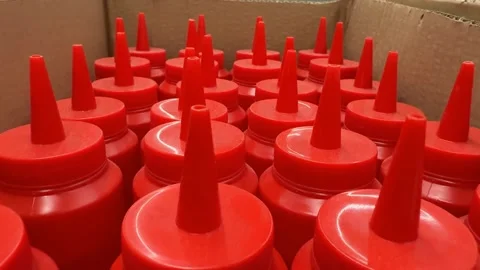 Red plastic squeeze bottles with pointed caps arranged in cardboard box, su.. Stock Footage 331031252