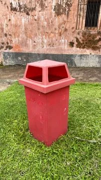 Red Plastic Trash Can with USE ME Text on Green Grass in Outdoor Setting 写真素材