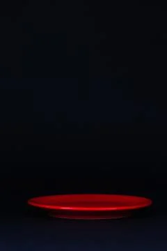 Red plate on the black table. 库存照片