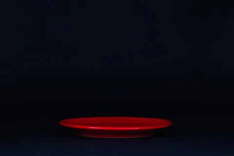 Red plate on the black table. Stock Photos