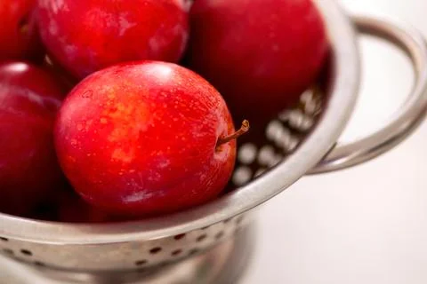 Red plums in a colander Stock Photos