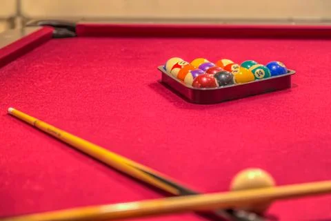 Red pool table with billiard balls in the rack Stock Photos