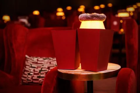 Red popcorn boxes on table in dim cinema interior Stock Photos