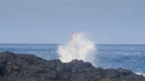 Red port or ship navigation buoy on big blue waves near black volcanic rock 動画素材 114689291