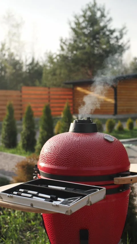 Red Portable Charcoal BBQ Grill Smokes Through Top Stock Footage 275647953