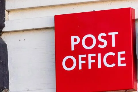 Red Post Office Sign on White Clapboard Wall in Ripon, UK. Stock Photos