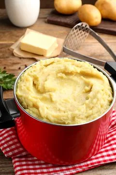 Red pot with tasty mashed potatoes on table Stock Photos