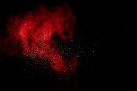 Red powder explosion on black background. Freeze motion of red dust particles Stock Photos