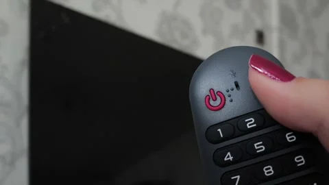 Red power button on the remote control in your hand against the background of a Stock Footage 318391152