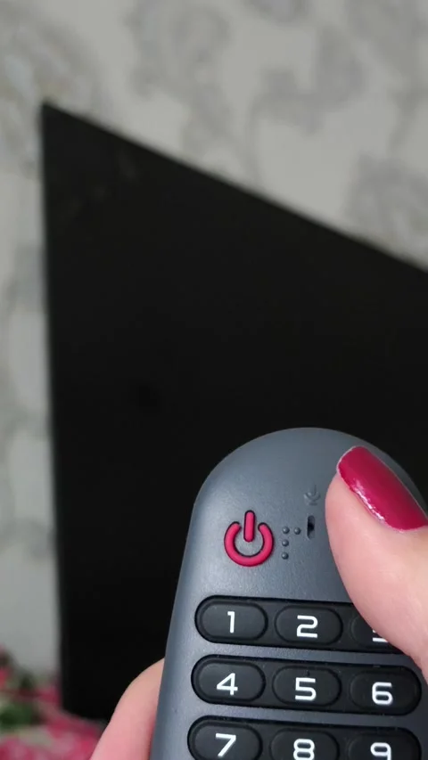 Red power button on the remote control in your hand against the background of a Stock Footage 318391210