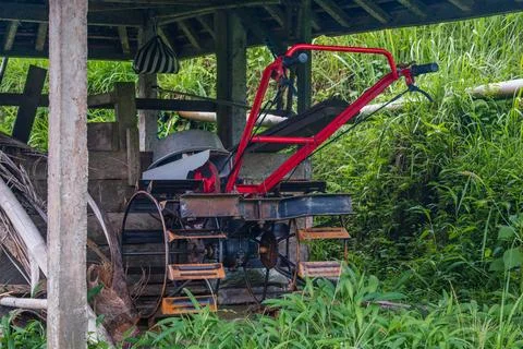 Red Power Tiller Parked in a Rustic Farm Shed Foto stock