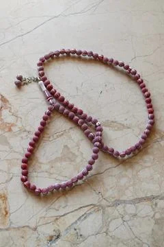 Red Prayer Beads On Marble Background Stock Photos