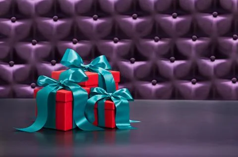 Red present in front of a button tufted background Stock Photos