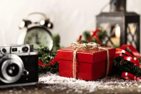 Red present gift box with camera and candle holder on wooden background Chris Stock Photos