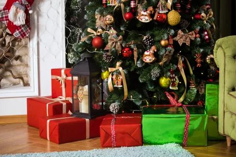 Red presents boxes under decorated New Year tree Stock Photos