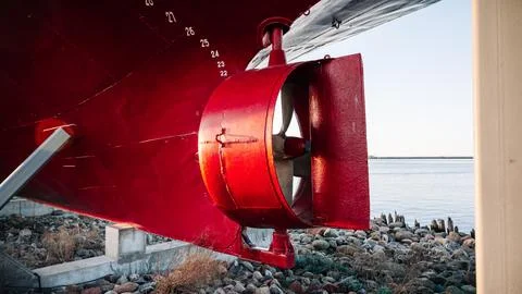 A red propeller is on the side of a boat Stock Photos