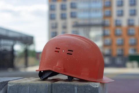 Red protective construction helmet on a construction site, with a background  Stock Photos