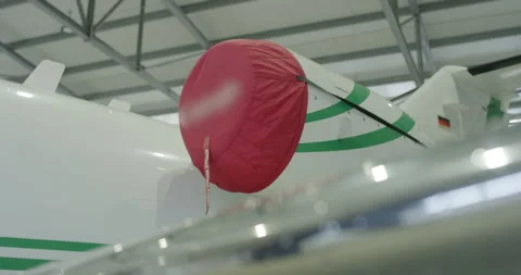 Red protective engine cover on a white private airplane in a hangar Video stock 329550207
