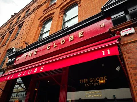 Red pub front of The Globe with red awning and brick facade in Dublin, Irel.. Stock Photos