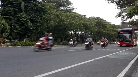 A red public bus passes on the streets of Surabaya Stock Footage 220534063