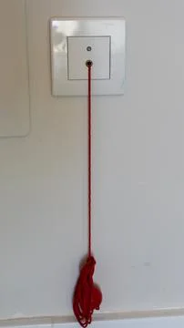 Red Pull Cord Hanging From Wall Electrical Switch Indoors Foto stock