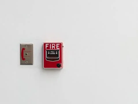 Red Pull-Down Fire Alarm Button Box and Phone Jack Connection Against White Wall Photos