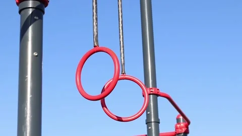 Red pull-up rings on the sky background Stock Footage 332169254